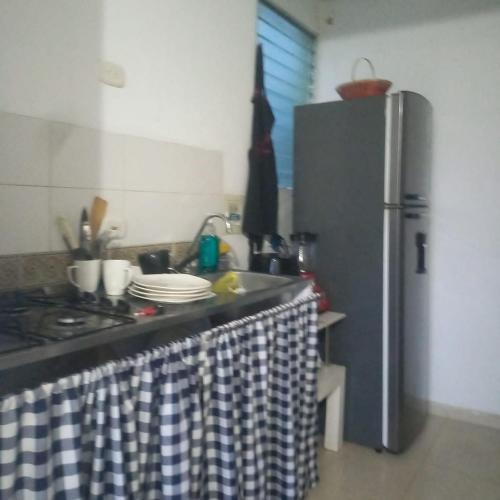 a kitchen with a stove and a refrigerator at Habitacion valledupar in Valledupar