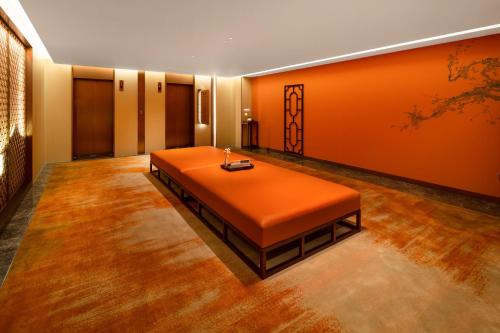 an orange room with a table in the middle at Guangzhou Wogo Yuanbao Hotel-Zhujiang New Town-Free Canton Fair Shuttle Bus & Overseas Buyer Registration Services in Guangzhou