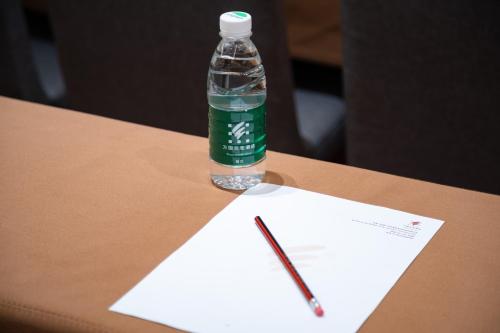 a bottle of water and a pencil on a paper at Guangzhou Wogo Yuanbao Hotel-Zhujiang New Town-Free Canton Fair Shuttle Bus & Overseas Buyer Registration Services in Guangzhou