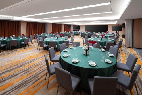 a conference room with tables and chairs and a stage at Guangzhou Wogo Yuanbao Hotel-Zhujiang New Town-Free Canton Fair Shuttle Bus & Overseas Buyer Registration Services in Guangzhou