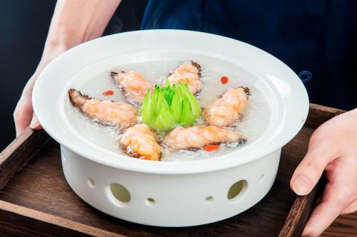 a bowl of shrimp and broccoli on a tray at Guangzhou Wogo Yuanbao Hotel-Zhujiang New Town-Free Canton Fair Shuttle Bus & Overseas Buyer Registration Services in Guangzhou
