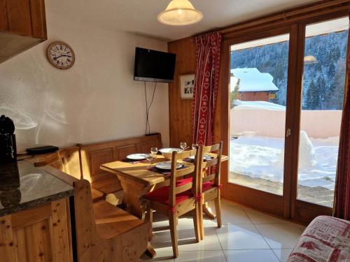 une salle à manger avec une table et une grande fenêtre dans l'établissement Joli T2 classé 1* au pied des pistes et téléphérique de Nyon - Morzine, avec parking et wifi - FR-1-754-31, à Morzine