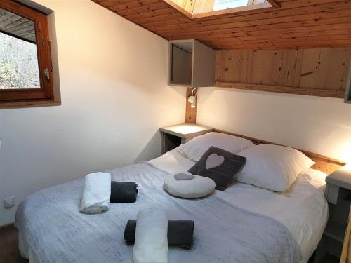 une chambre avec un lit avec deux oreillers dessus dans l'établissement Appartement rénové, 4 pers, pied des pistes de Nyon, Morzine, parking, wifi et animaux acceptés - FR-1-754-48, à Morzine