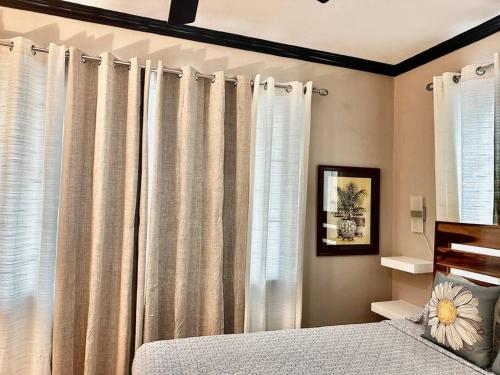 um quarto com uma cama e uma janela com cortinas em The Shelton Tower 1 em Montego Bay