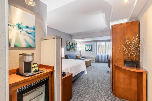 a hotel room with a bed and a tv at Courtyard by Marriott Boston Waltham in Waltham