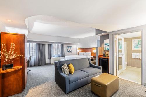 um quarto de hotel com um sofá e uma cama em Courtyard by Marriott Boston Waltham em Waltham