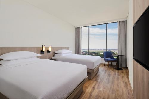 a hotel room with two beds and a window at Fairfield by Marriott Jakarta Soekarno-Hatta Airport in Tangerang
