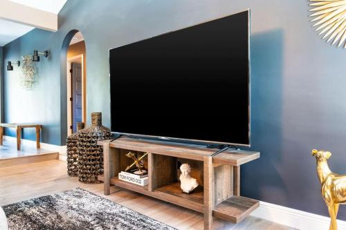 a living room with a large flat screen tv on a wall at The Sinatra - Fun 5BD Home Huge Pool Game Room in Round Rock