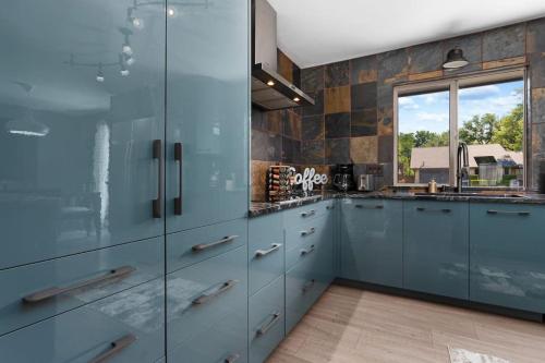 a kitchen with blue cabinets and a window at The Sinatra - Fun 5BD Home Huge Pool Game Room in Round Rock