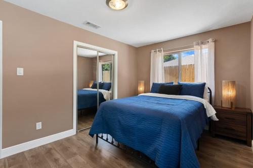 a bedroom with a blue bed and a mirror at The Sinatra - Fun 5BD Home Huge Pool Game Room in Round Rock