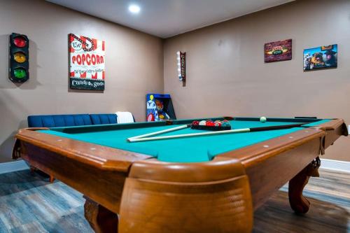 a room with a pool table with cuesticks on it at The Sinatra - Fun 5BD Home Huge Pool Game Room in Round Rock
