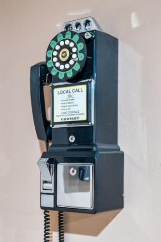 a black cell phone is hanging on a wall at The Sinatra - Fun 5BD Home Huge Pool Game Room in Round Rock