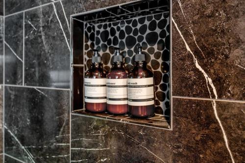 a shelf with four bottles of alcohol on a wall at The Sinatra - Fun 5BD Home Huge Pool Game Room in Round Rock