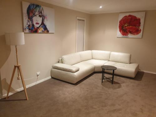 a living room with a white couch and a table at Ensuite room with Private Bath toilet CBD Airport in Werribee