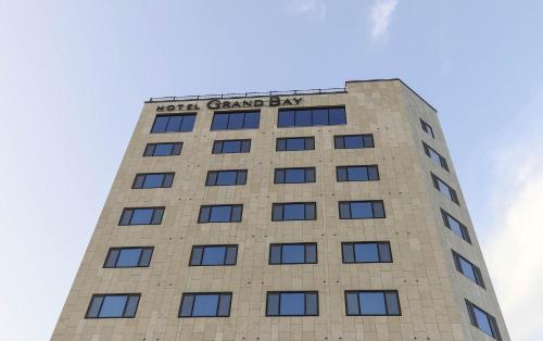 a tall building with a sign on the top of it at Hotel Grand Bay Boryeong in Boryeong