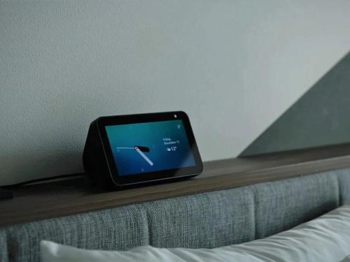 a digital clock sitting on top of a bed at Prince Smart Inn Atami in Atami