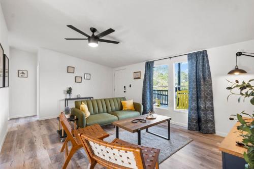 a living room with a green couch and a table at Starlight Horizon Cabin M - Pet-Friendly Texas Hill Country Cabin Near Canyon Lake - Pool, Stargazing & Group Getaways - Sleeps 8 in Canyon Lake
