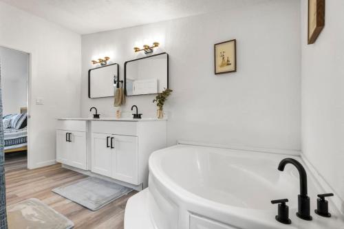 a white bathroom with a tub and a sink at Starlight Horizon Cabin M - Pet-Friendly Texas Hill Country Cabin Near Canyon Lake - Pool, Stargazing & Group Getaways - Sleeps 8 in Canyon Lake