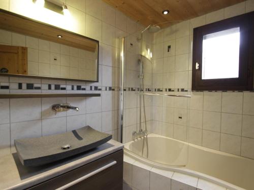 a bathroom with a sink and a bath tub at Appartement Morzine, 3 pièces, 6 personnes - FR-1-754-54 in Morzine