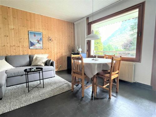 un salon avec une table et un canapé dans l'établissement Charmant T2 à Morzine, balcon, parking, 4 pers., proche pistes et navettes - FR-1-754-53, à Morzine