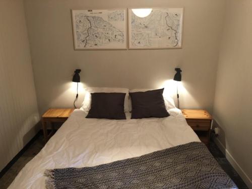 a bedroom with a bed with two lamps and maps on the wall at Appartement Morzine, 2 pièces, 4 personnes - FR-1-754-53 in Morzine