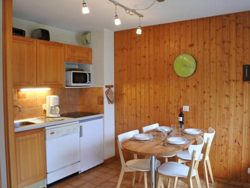 une cuisine avec une table et des chaises dans une cuisine dans l'établissement Studio cosy à 200m du centre et des pistes - Morzine - FR-1-754-70, à Morzine
