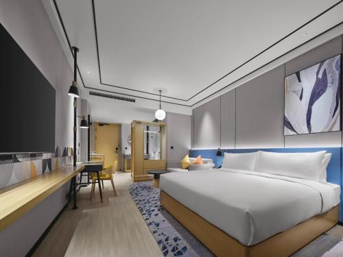 een hotelkamer met een bed en een bureau bij Hilton Garden Inn Xingtai Xiangdu District in Ta-liang-chuang