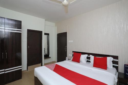 - une chambre avec un grand lit et des oreillers rouges dans l'établissement OYO Flagship 16892 The Resting Place, à Pānchuria
