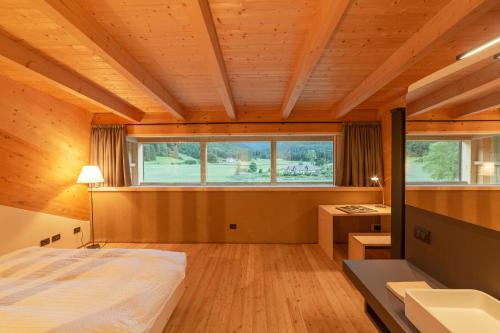 1 dormitorio con cama, escritorio y ventana en Maso Torbiera- Rural and Mountain lodging en Fiavè