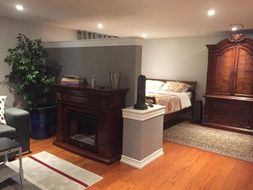 een slaapkamer met een bed, een dressoir en een open haard bij Private Retreat in Dundas in Hamilton