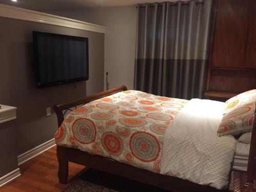 een slaapkamer met een bed en een flatscreen-tv bij Private Retreat in Dundas in Hamilton