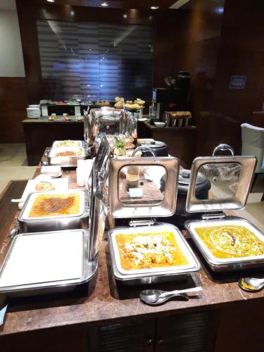 a buffet with many trays of food on a table at Four Points by Sheraton Vadodara in Vadodara