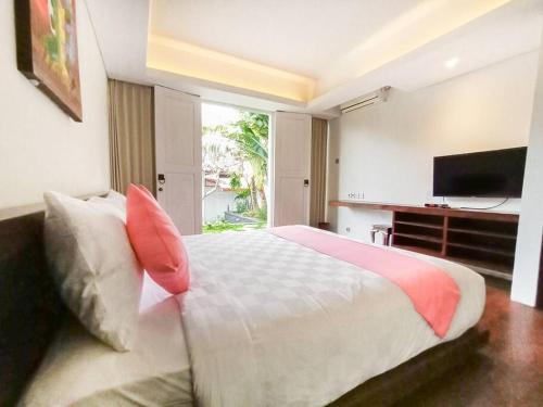 a bedroom with a large bed with a flat screen tv at Dzawani Villa Ungasan in Uluwatu