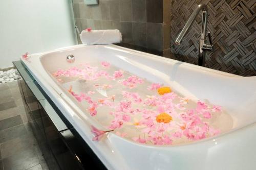 a bath tub with pink flowers in it at Dzawani Villa Ungasan in Uluwatu