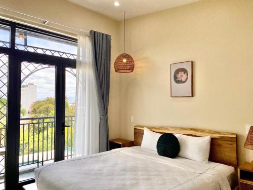 a bedroom with a bed and a large window at Hue Sweethouse 2 Homestay in Hue