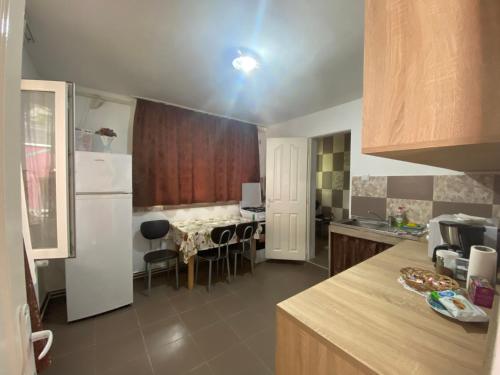 cocina con nevera blanca y mesa en Ardelean Apartment, en Oradea