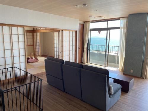 a living room with a couch and a large window at Support Inn Minami-Chita Annex Hamachaya in Minamichita
