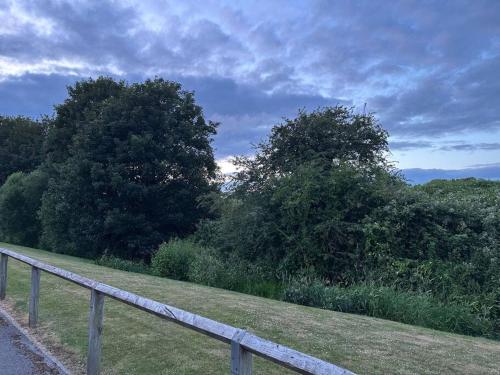 a fence on the side of a field with trees at Balne Mill Grove in Wakefield