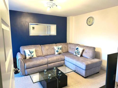 a living room with a couch and a clock on the wall at Balne Mill Grove in Wakefield