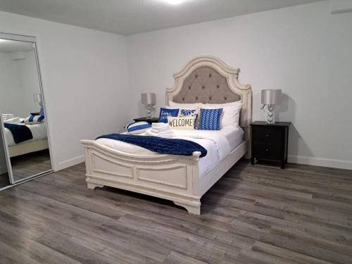 a bedroom with a large white bed with blue pillows at Suite ravissante MYD in Milton