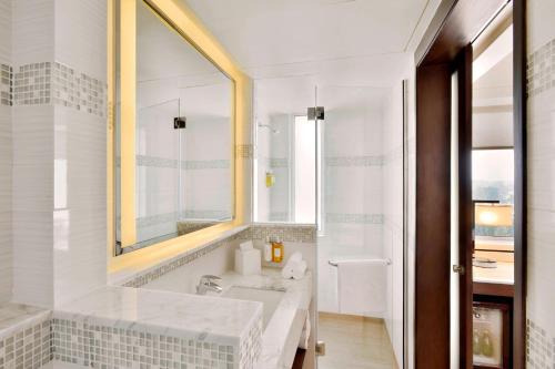 een badkamer met een bad, een wastafel en een spiegel bij Fairfield by Marriott Kathmandu in Kathmandu