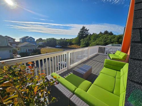 a balcony with two green chairs and a table at Sunkissed, Est 2015 - 90 Sec Drive to Beach, Firepit, Privacy Fenced Yard, Gardens in Pacific Beach