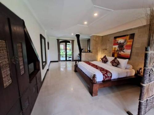 1 dormitorio con 1 cama y TV en Dzawani Villa Ubud, en Tampaksiring