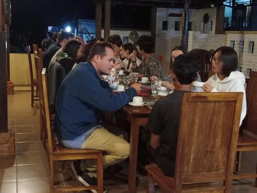 a group of people sitting at a table in a restaurant at KARANG SARI Guesthouse in Munduk