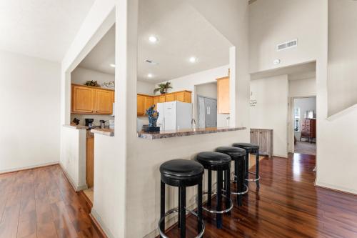 a kitchen with a row of stools at a bar at Puttin on the Green Villa in Branson West