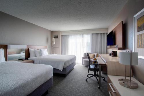 een hotelkamer met 2 bedden en een bureau bij Courtyard by Marriott New Orleans Warehouse Arts District in New Orleans