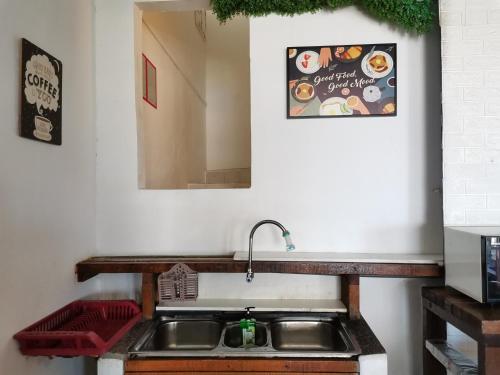 eine Küchentheke mit einem Waschbecken und einem Spiegel in der Unterkunft Greenage Seaview Bay Villa with stunning sunset in Putatan