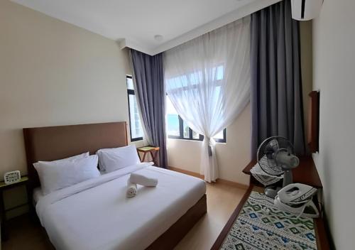 een hotelkamer met een bed en een raam bij Timurbay Seafront Residence in Kuantan