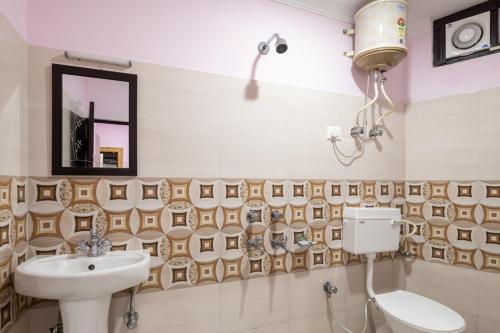 Vella Marina Group of hotels Mcleodgunj في دارامشالا: حمام مع حوض ومرحاض ومرآة