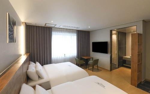 a hotel room with a white bed and a desk at Hotel Grand Bay Boryeong in Boryeong